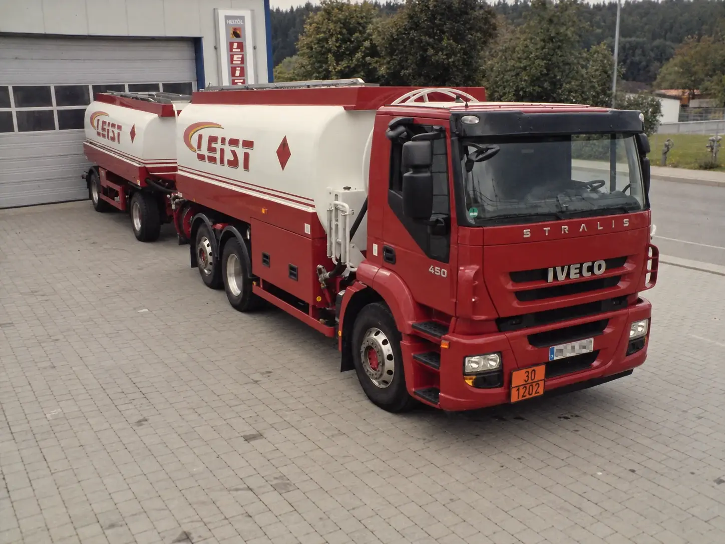 Ein rot-weißer Leist-Tankzug vor der Fahrzeughalle am Betriebsgelände